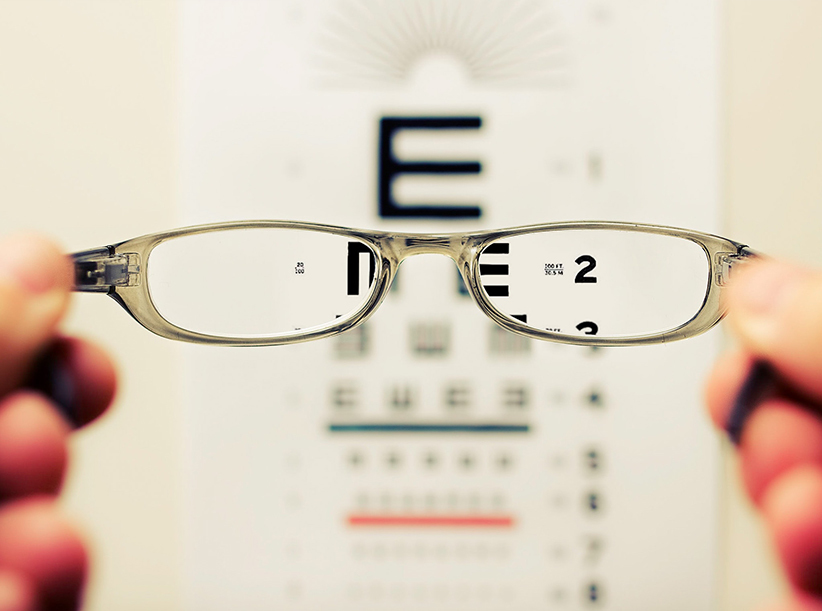 Holding up glasses in front of an eye test