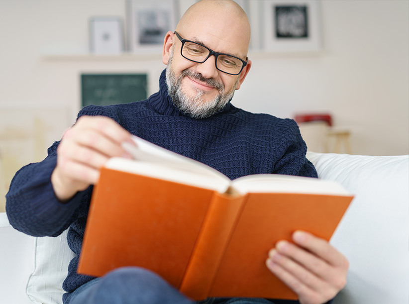 Man reading book on couch